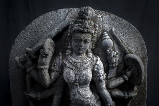 A statue of the goddess Durga against a dark background