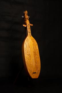 A Sapeq karaang musical instrument on a dark background