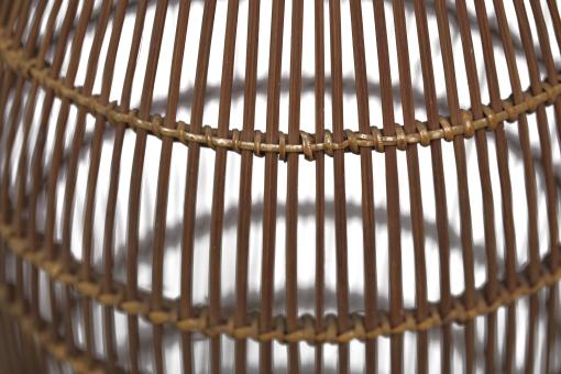 Detail of a tall, slender bamboo Fish Trap (Bubu) with a conical shape and woven grid pattern.
