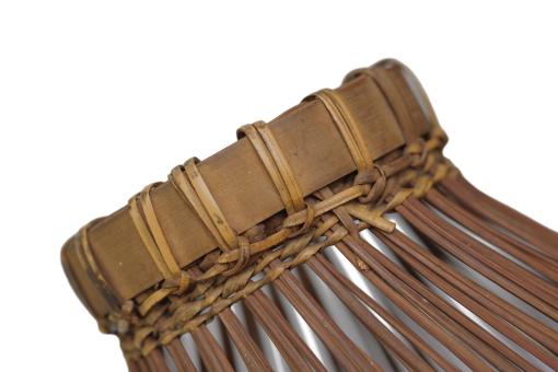 Detail of a tall, slender bamboo Fish Trap (Bubu) with a conical shape and woven grid pattern.
