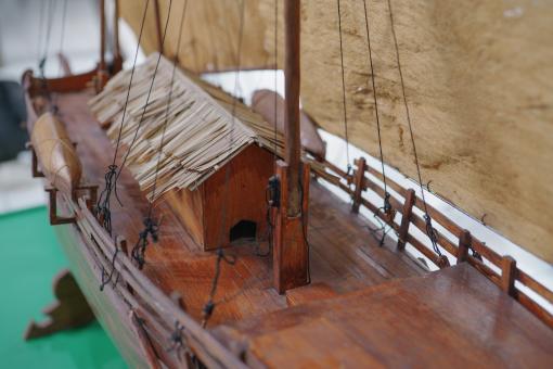Image depicting a Padewakang Boat Miniature, a small wooden sail boat on display