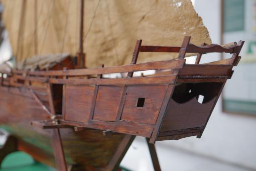 Image depicting a Padewakang Boat Miniature, a small wooden sail boat on display