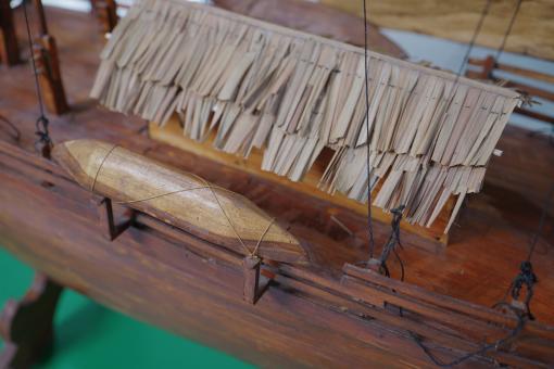 Image depicting a Padewakang Boat Miniature, a small wooden sail boat on display