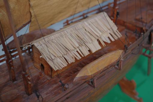 Image depicting a Padewakang Boat Miniature, a small wooden sail boat on display