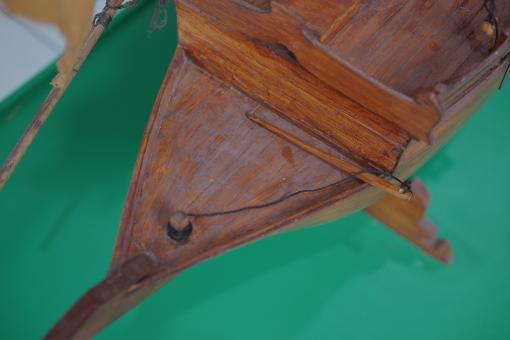 Image depicting a Padewakang Boat Miniature, a small wooden sail boat on display