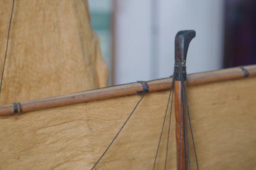 Image depicting a Padewakang Boat Miniature, a small wooden sail boat on display