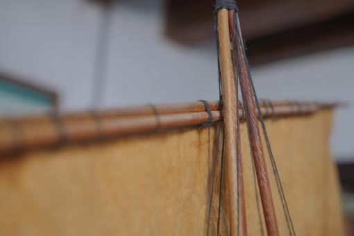 Image depicting a Padewakang Boat Miniature, a small wooden sail boat on display