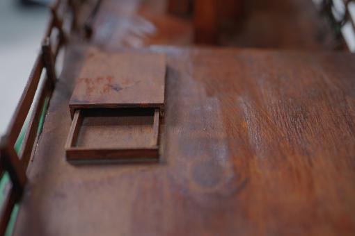 Image depicting a Padewakang Boat Miniature, a small wooden sail boat on display