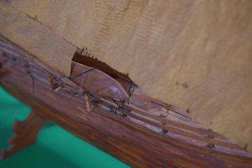 Image depicting a Padewakang Boat Miniature, a small wooden sail boat on display