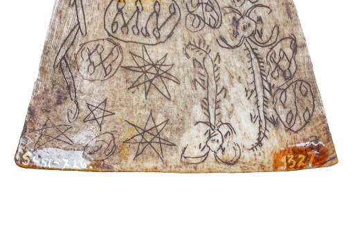 Detail of a triangular amulet with various images etched into its surface