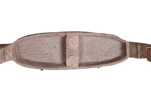 A miniature wooden carved boat with dog-shaped ornaments
