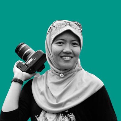 A black and white portrait of Zainab against a aquamarine background