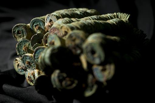 Chinese coins in concretion against a dark background